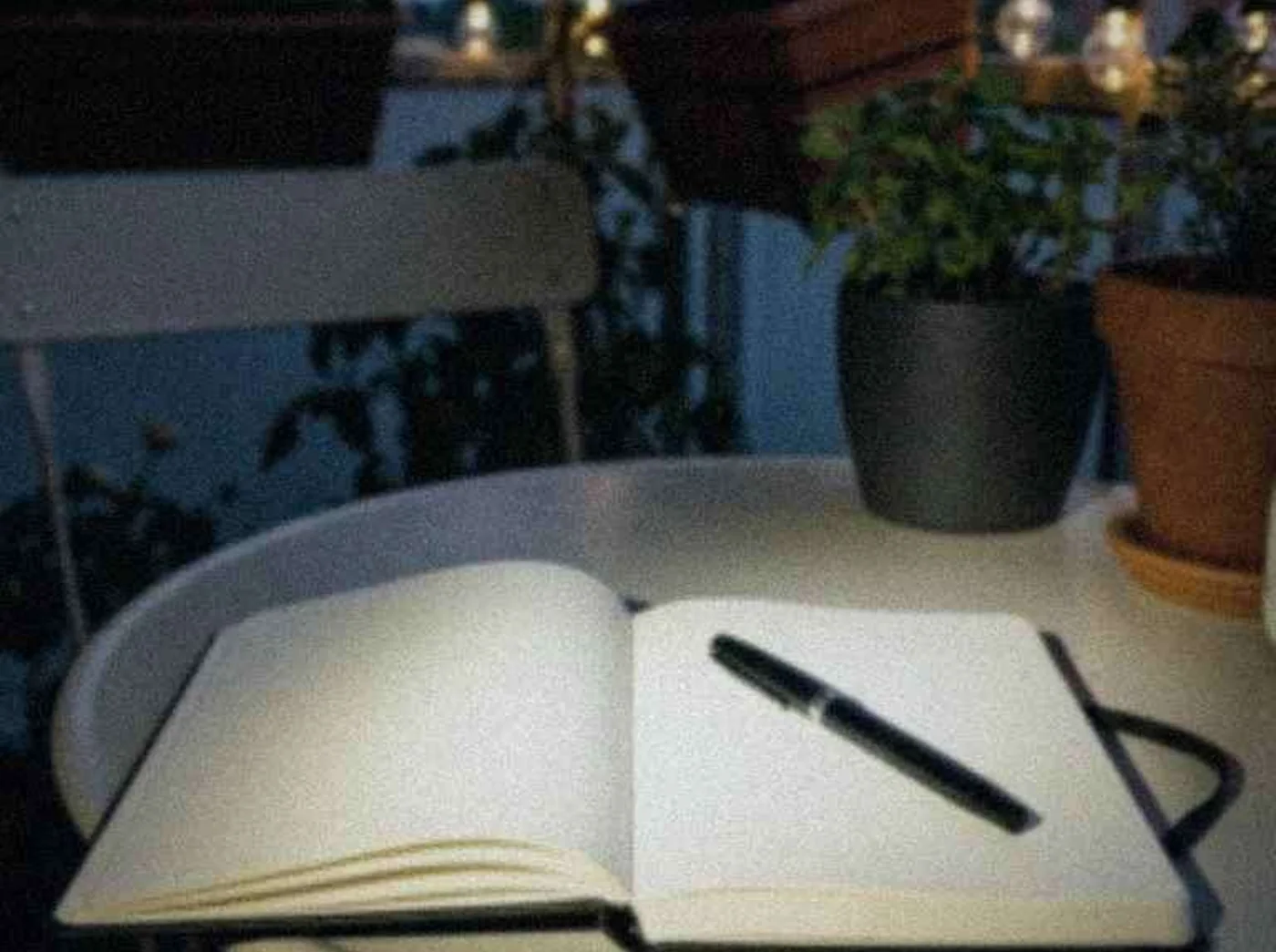 Open paper journal and pen on a quiet balcony table