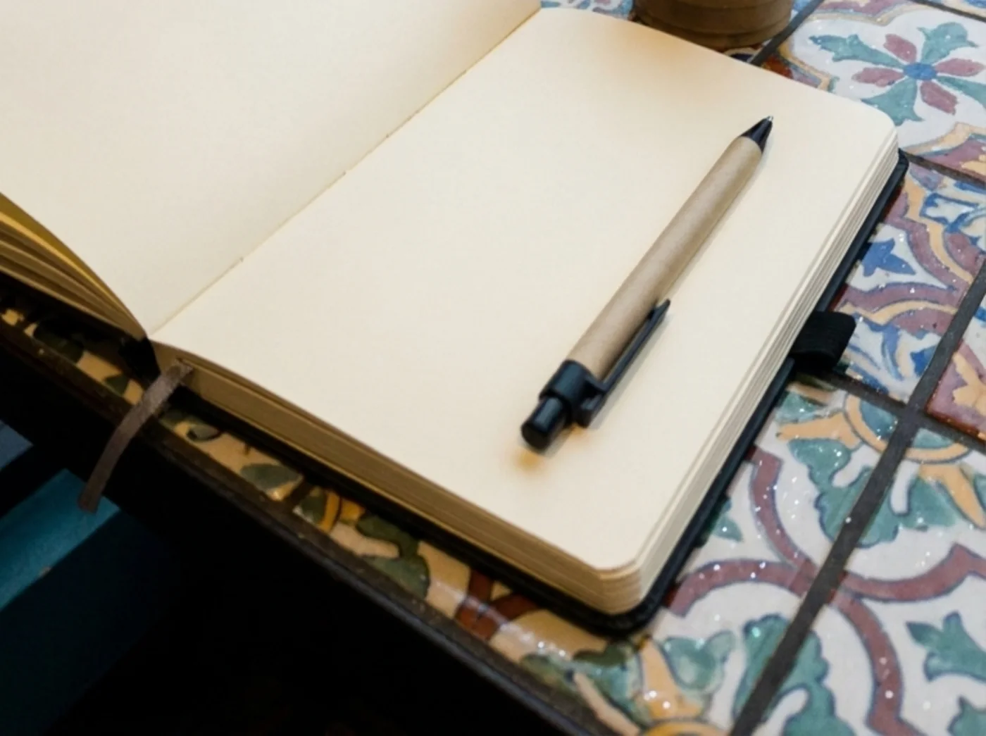 Open paper journal and pen on a cafe table by a window